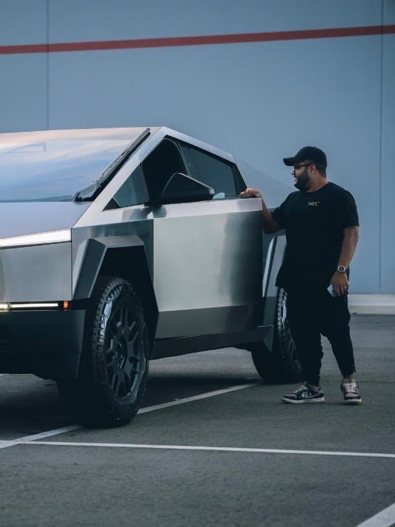 Cayo Lima standing beside his truck in a parking lot at dusk