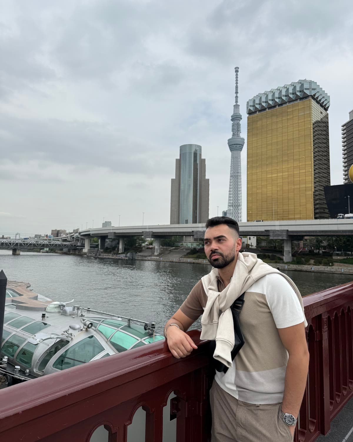 Obada Alsalhani on a bridge over the river in Tokyo